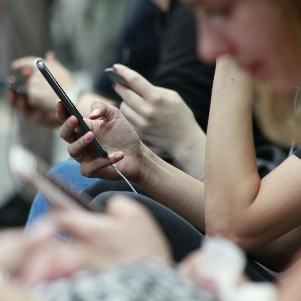 people sitting disconnected from one another using social media